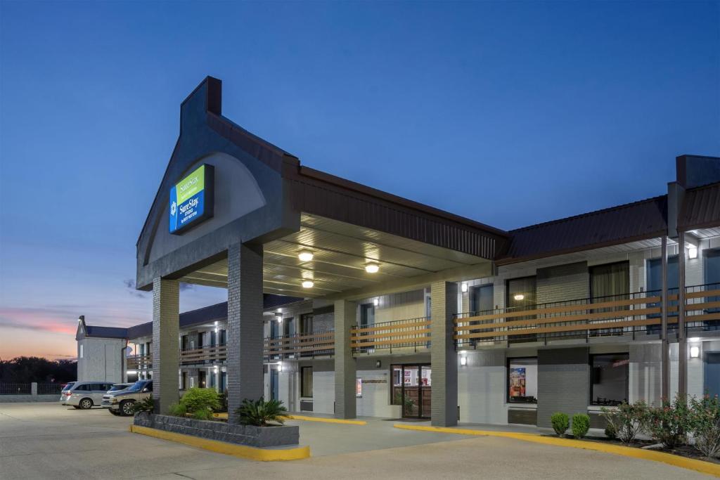 ein Gebäude mit einer Uhr an der Vorderseite in der Unterkunft SureStay Studio by Best Western Gonzales in Gonzales