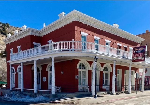 a red building with a balcony on top of it at Jackson House Hotel in Eureka