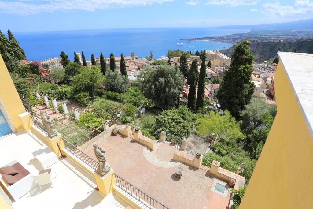 een uitzicht op de stad vanuit een gebouw met bomen bij Casa Cuseni, Patrimonio Culturale Immateriale UNESCO in Taormina