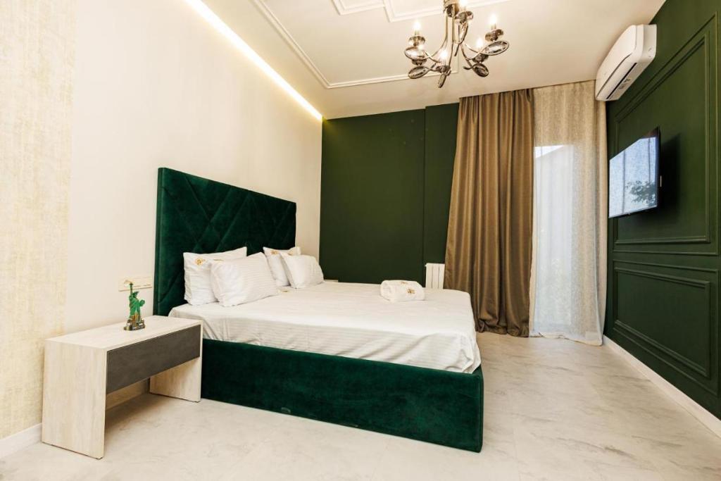 a bedroom with a bed with a green wall at New York Hotel Yerevan in Yerevan