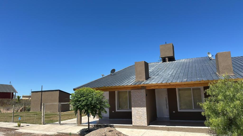 a house with a metal roof on top of it at Duplex en villa el chocon LO DE CARLITOS in Villa El Chocón