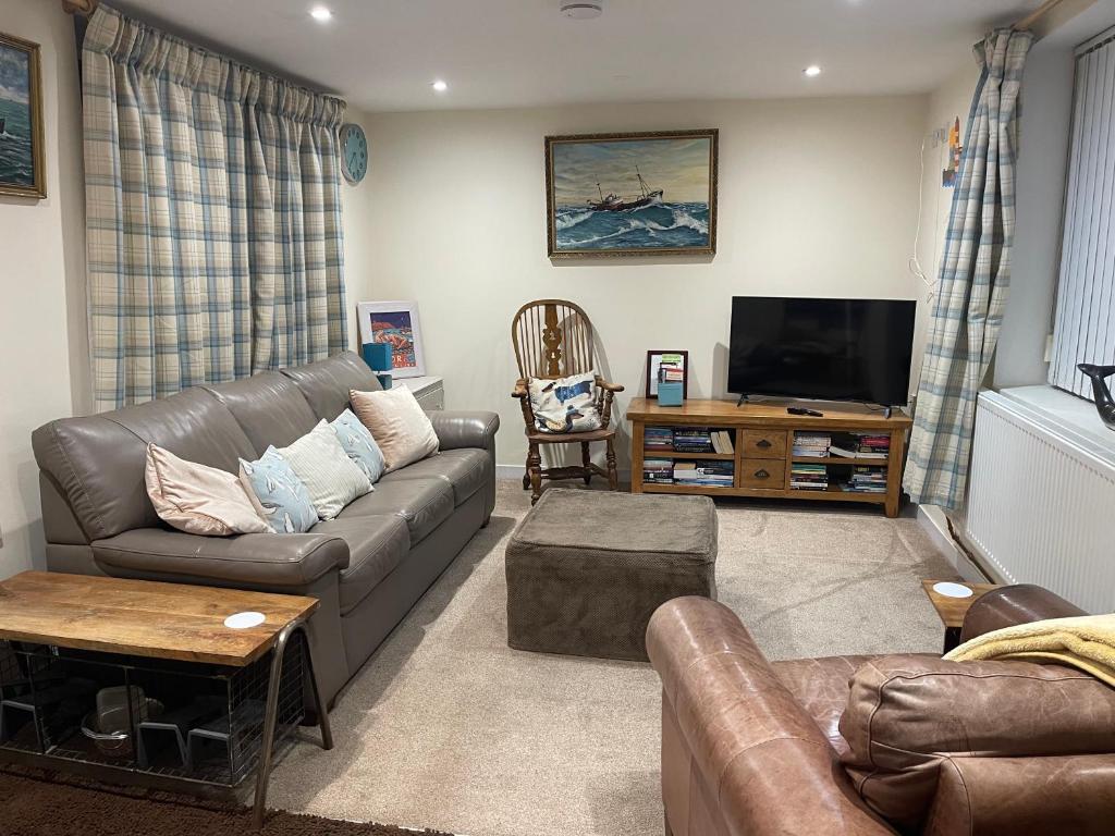 a living room with a couch and a tv at Hope Corner in Filey