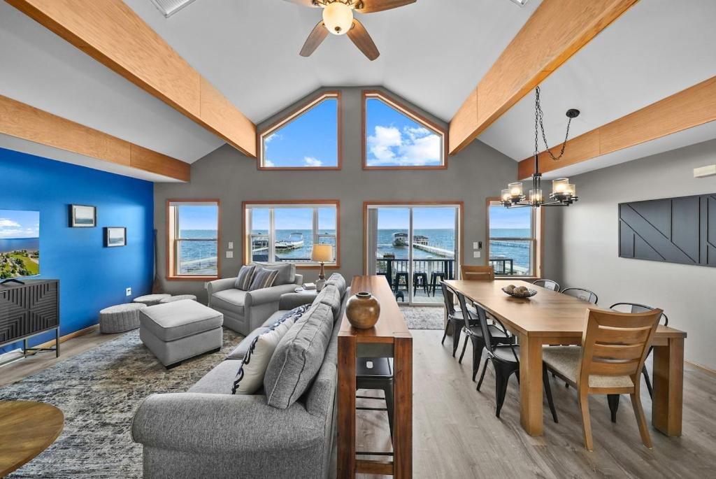 a dining room and living room with a table and chairs at Beach Front Houghton Lake with Game Room in Port Huron