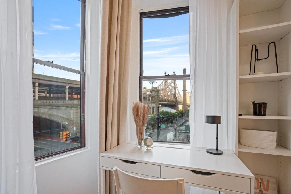 a desk in a room with a large window at Warm and Welcoming 2BR in Upper East Side in New York