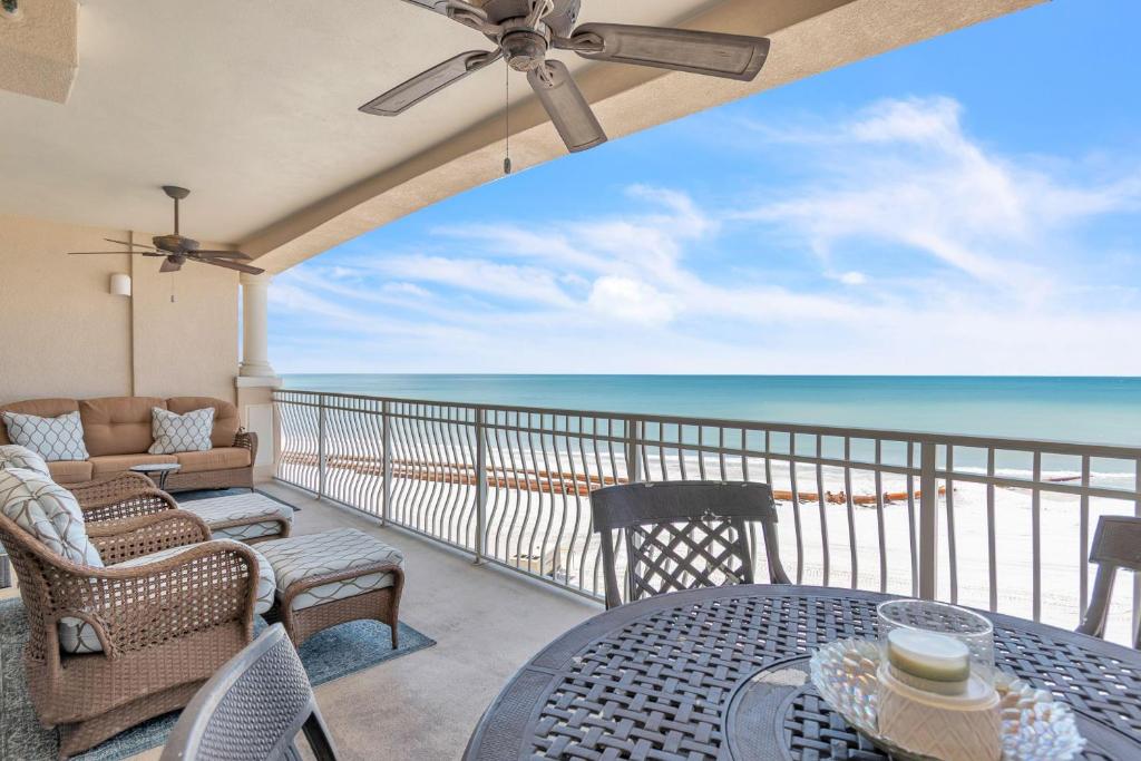 a balcony with a table and chairs and the ocean at La Vistana #A503 in St Pete Beach