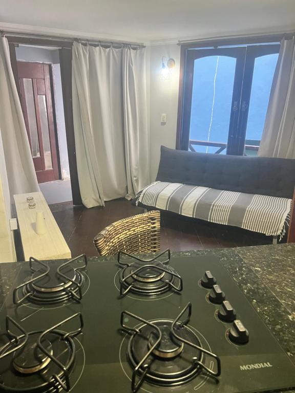 a kitchen with a stove top in a living room at Flat Serena in Cayru