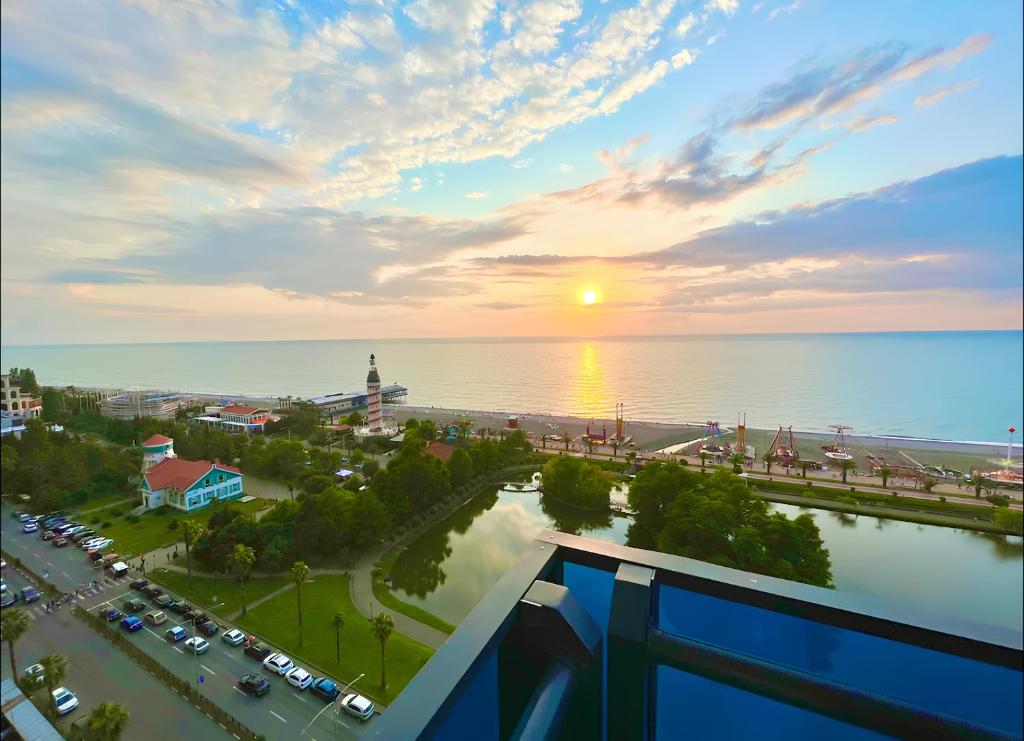 a view of a city with a sunset over the ocean at ORBI CITY - Lovely Apartments in Batumi