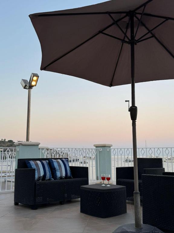 a black umbrella sitting on top of a balcony at Blue Tao Maison Taormina in Taormina