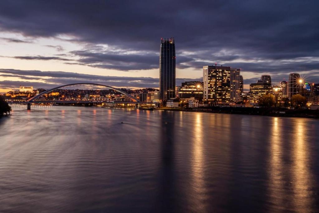 - une vue sur une rivière avec une ville la nuit dans l'établissement Eurovea Tower apartment, à Ovsište