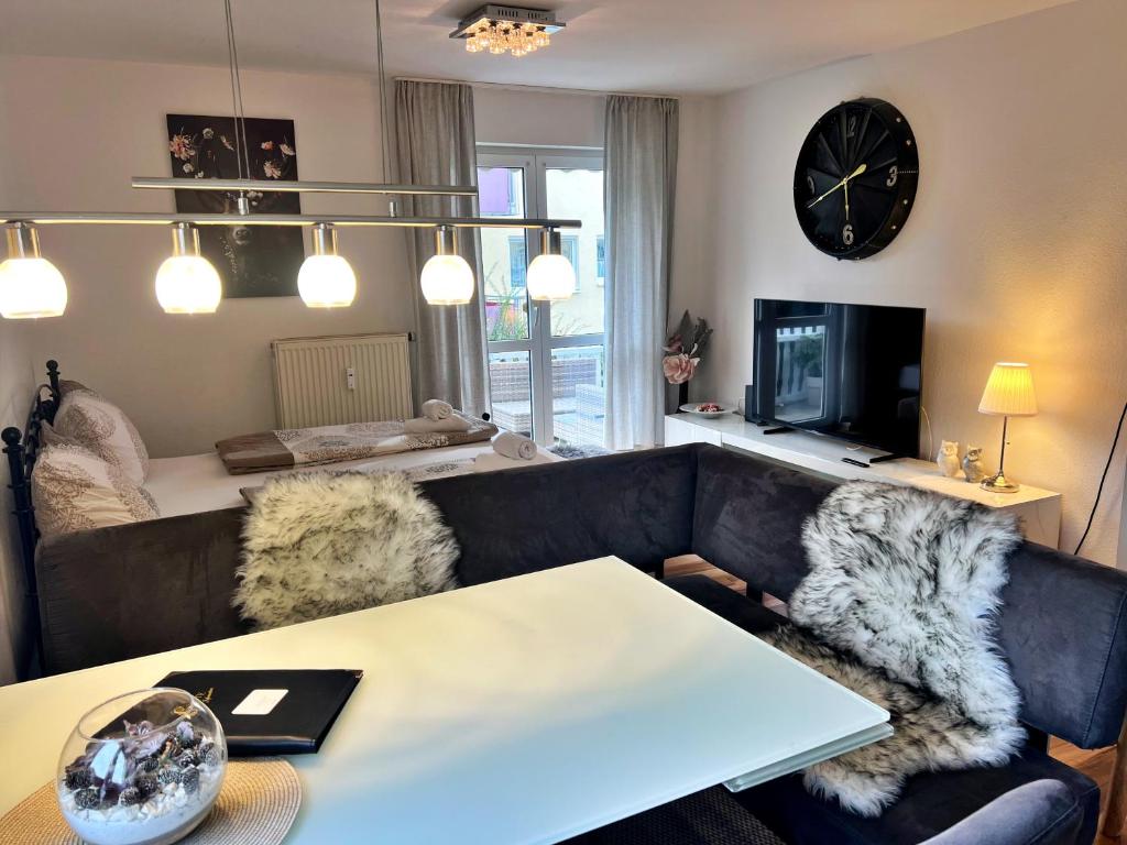 a living room with a couch and a table and a clock at Stellina Apartment beim Europa Park Rust in Rust