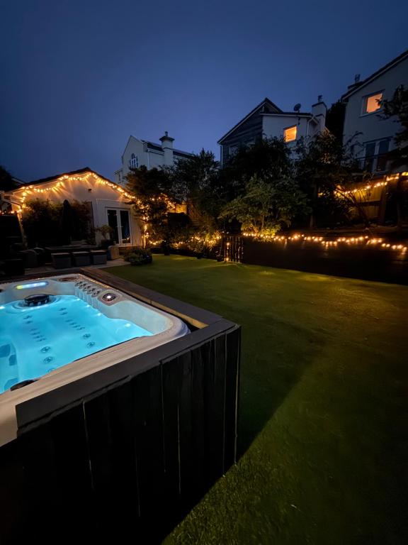 a backyard with a hot tub in a yard with lights at Portishead Coastal Retreat in Portishead