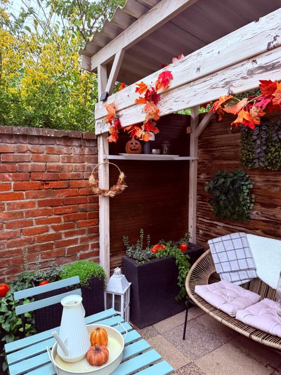 een patio met een tafel en stoelen en een pergola bij Maisonnette individuelle au coeur de Vernon in Vernon
