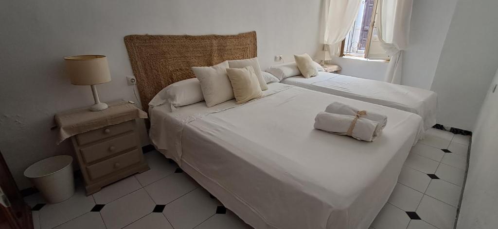 Un dormitorio con una gran cama blanca con dos almohadas. en Habitación en Zoco Home, en Almería