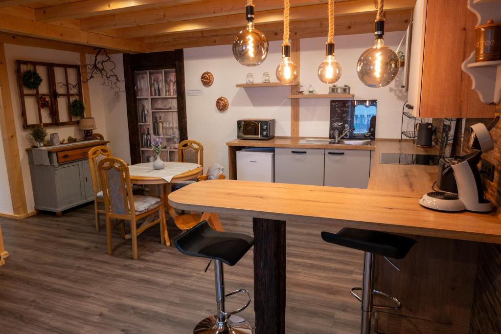 een keuken met een aanrecht, een tafel en stoelen bij Gemütlichkeit in Heltersberg