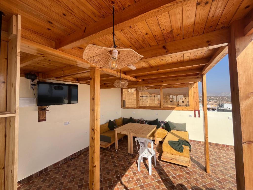 une terrasse avec un plafond en bois, une table et des chaises dans l'établissement Tafokt surf house, à Taghazout