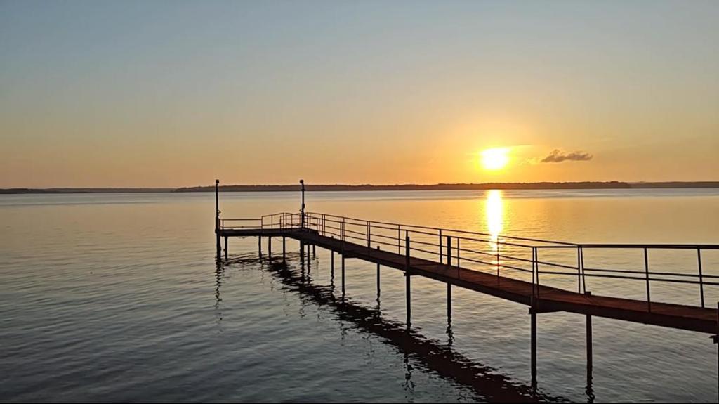 un molo su uno specchio d'acqua al tramonto di LaRue's Private Lakeside Cottage ad Abbeville