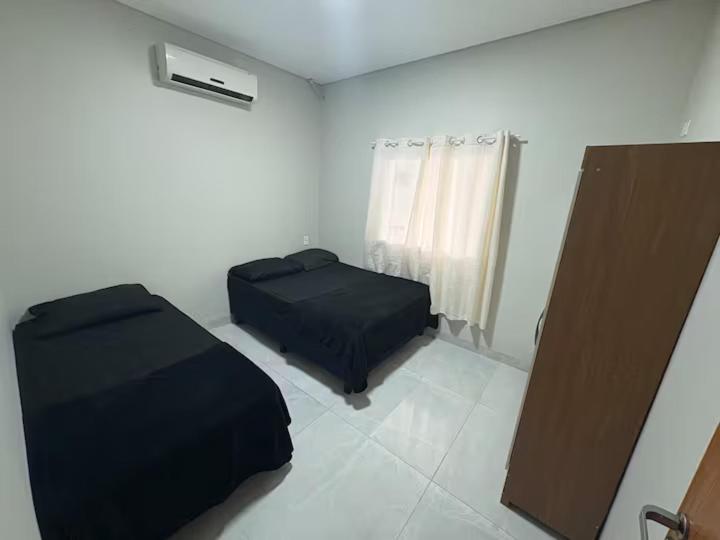 a small bedroom with a bed and a window at Estadia Incrível Aconchego e Praticidade Juntas in Lucas do Rio Verde
