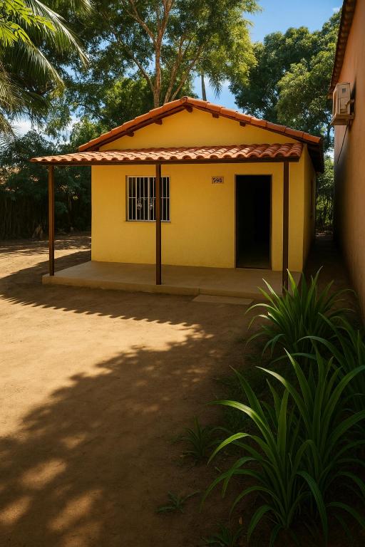 una pequeña casa amarilla con techo en Chalé Rústico Cumuruxatiba, en Cumuruxatiba