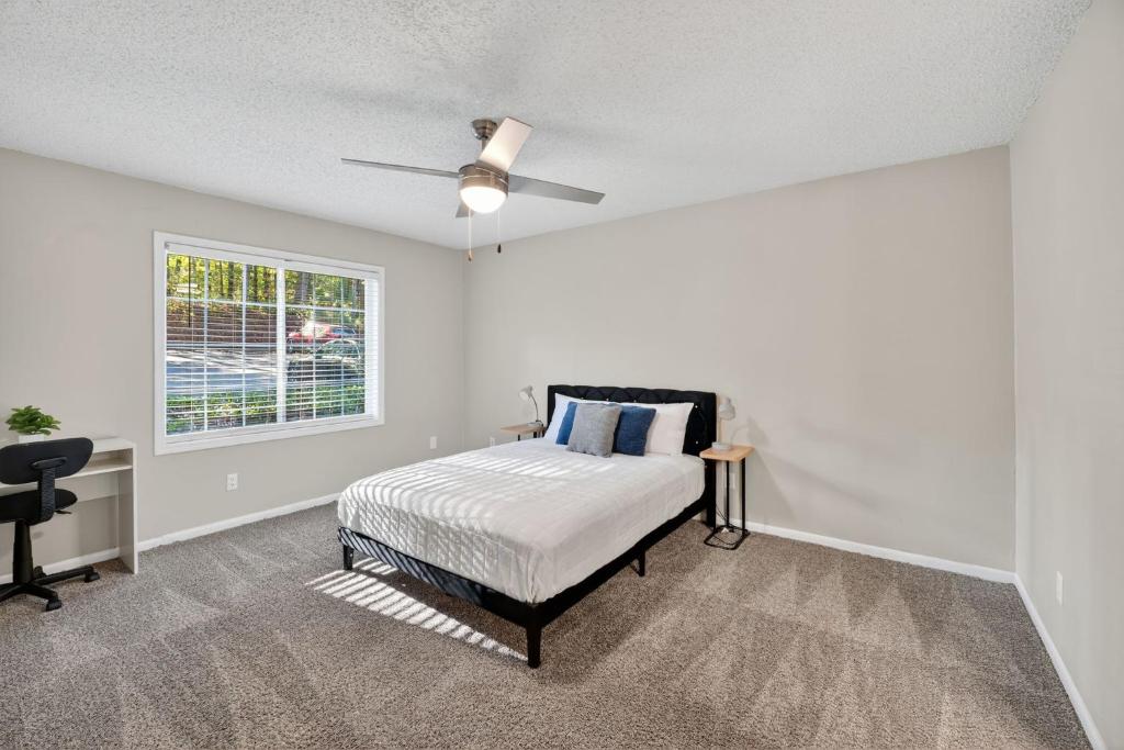 une chambre avec un lit et un ventilateur de plafond dans l'établissement Crest At East Cobb 1830 Sleek & Cozy 2bd 2bt, à Marietta