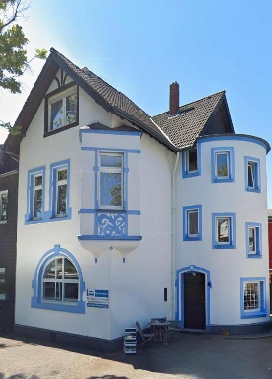 a white house with blue trim at Ferienwohnung Gästehaus Bauer 2 in Heiligenhaus