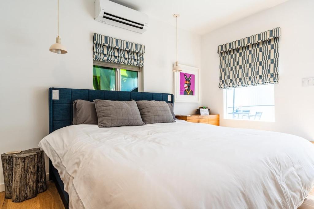 ein Schlafzimmer mit einem großen Bett mit blauem Kopfteil in der Unterkunft Simple La Jolla Epic bungalow # 3 in San Diego