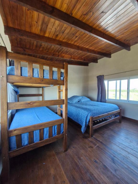 a bedroom with two bunk beds and a wooden ceiling at Los sauces in Gualeguaychú