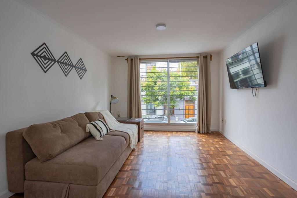 a living room with a couch and a television at Hermoso duplex en Palermo in Montevideo