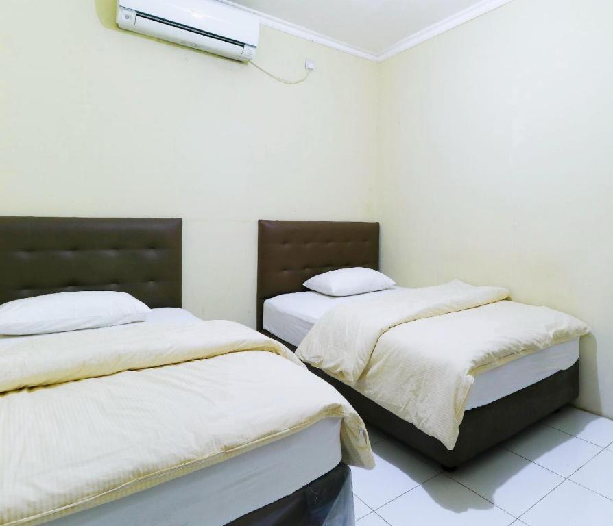 Dos camas en una habitación con paredes blancas. en Indra Homs, 