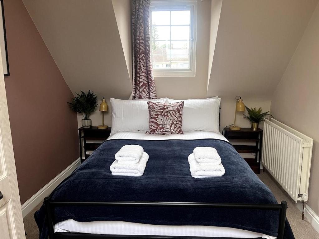 a bedroom with a large bed with towels on it at Hazel House - Cosy 2 bedroom house with parking near to Oxford in Oxford