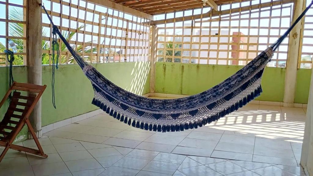 a hammock hanging in a room in a building at Casa com 5 suítes e Churrasqueira para 12 pessoas in Atalaia