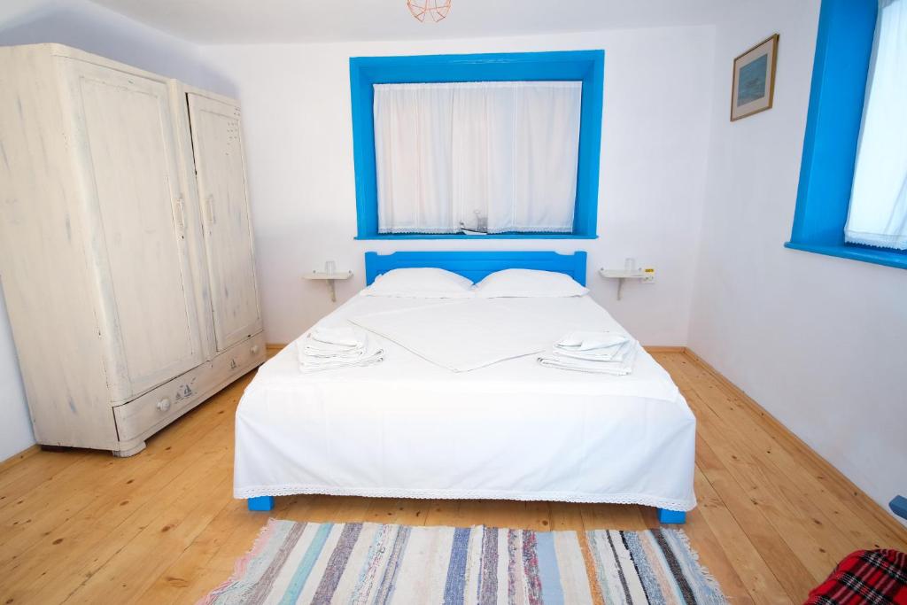 Schlafzimmer mit einem Bett mit blauem Kopfteil in der Unterkunft La Lipoveni in Jurilovca