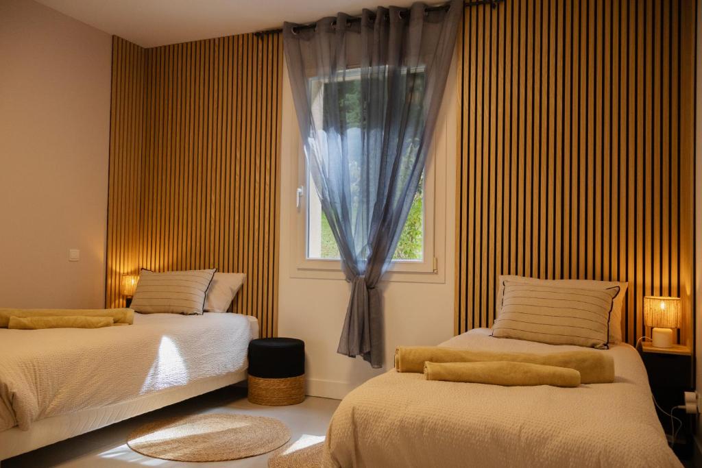een slaapkamer met twee bedden en een raam bij Mon havre de paix, Villa Campagne Charentaise in Mansle