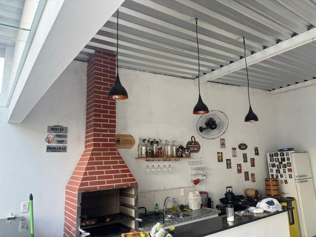 een keuken met een stenen oven en twee hanglampen bij Chácara embaixador in Hortolândia
