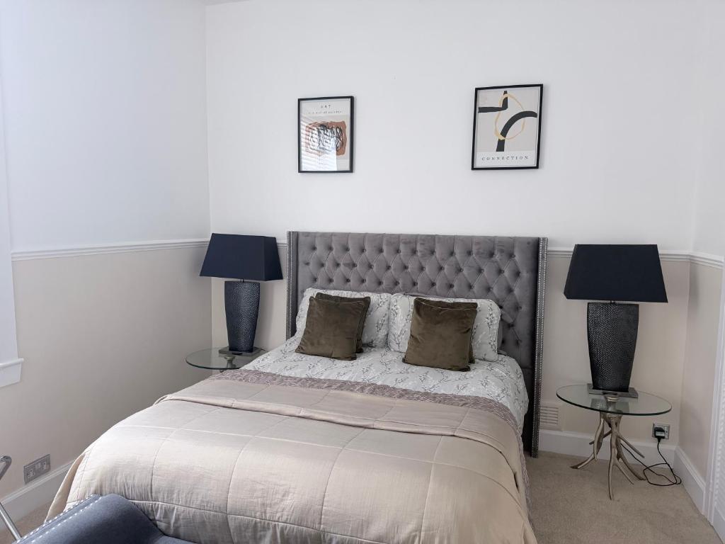 a bedroom with a bed with two tables and two lamps at Prestwick serviced apartment in Prestwick