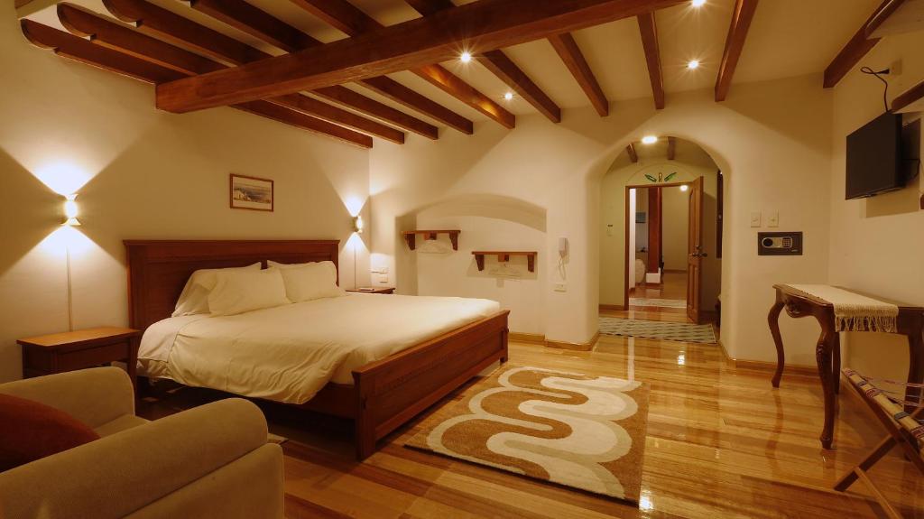 um quarto com uma cama e uma sala de estar em Casa Lucía Hotel by Las Plazas em Ascázubi