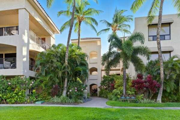 een gebouw met palmbomen ervoor bij Golf Course Townhome in Waikoloa Beach in Waikoloa