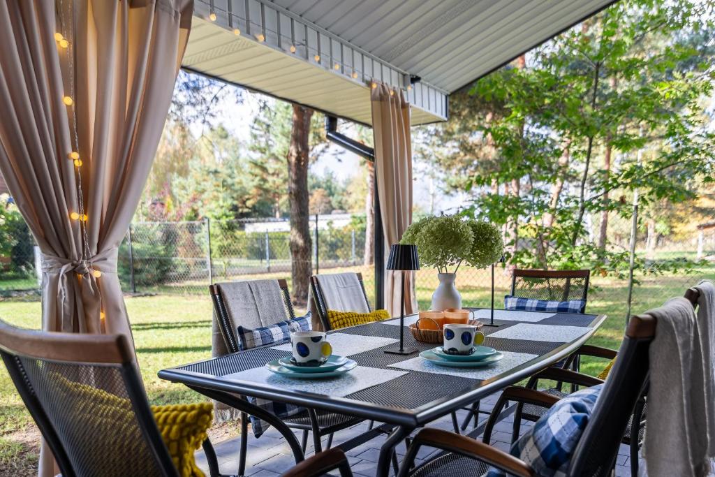a patio with a table and chairs on a porch at Domek W Sosnach Poleski Park Narodowy in Grabniak