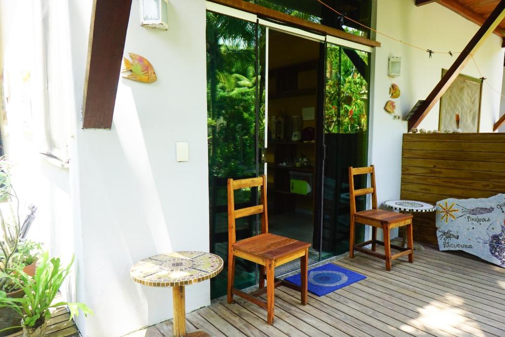 a porch with two chairs and a table at Barra Quintal - Studio 1 in Barra Grande