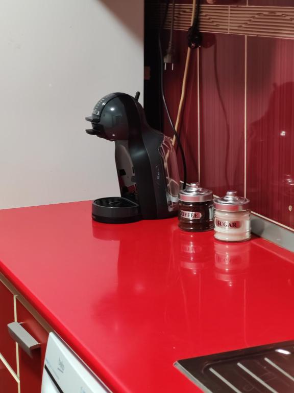 a red counter top with a coffee maker on it at Apartament 2 camere decomandat! in Ploieşti