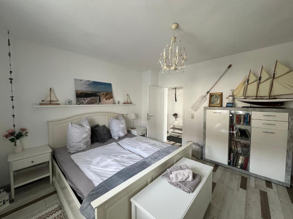 ein kleines Schlafzimmer mit einem Bett und einem Kronleuchter in der Unterkunft Villa Wohli 4 Sterne FERIENWOHNUNG AM HARZ in Nordhausen