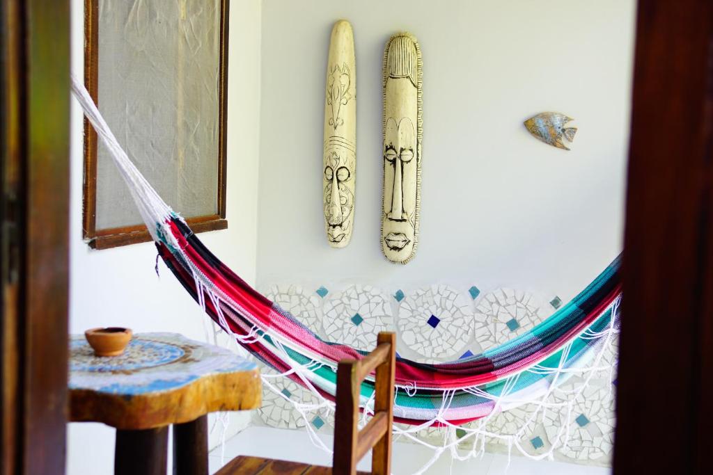 a hammock hanging on a wall next to a table at Barra Quintal - Studio 2 in Barra Grande