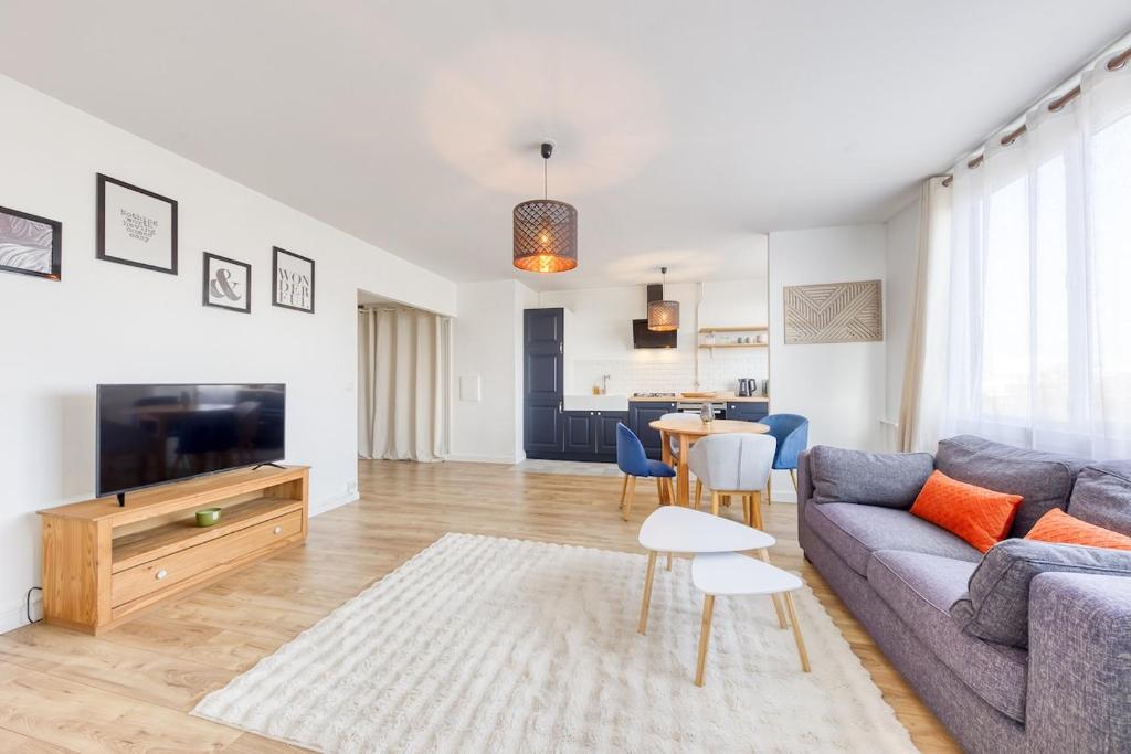 a living room with a couch and a table at Relaxation near Paris in Saint-Denis