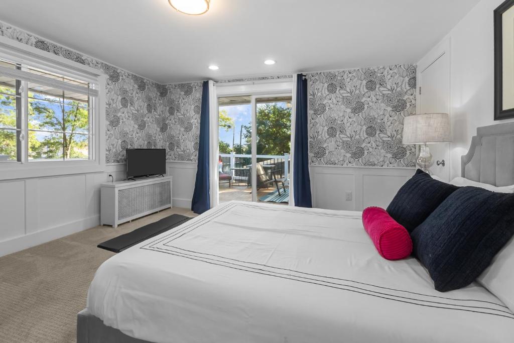 a bedroom with a large white bed with red pillows at The American House in Williams Bay in Lake Geneva