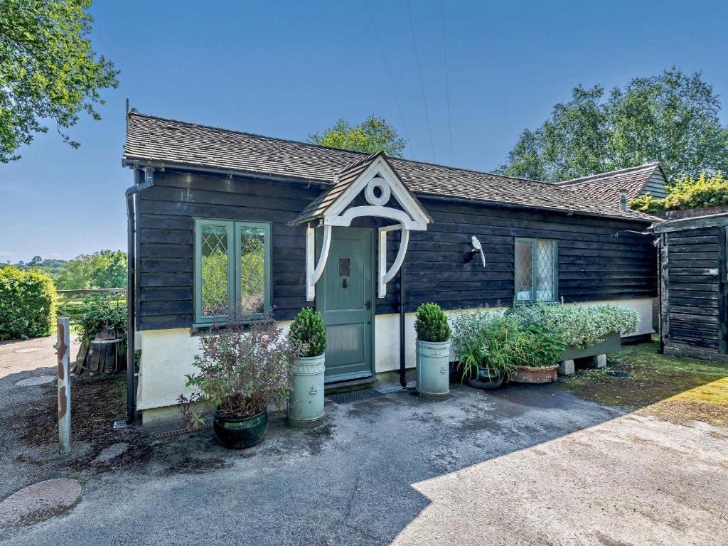 a small house with a green door and some plants at 1 Bed in Lamberhurst 79180 in Wadhurst