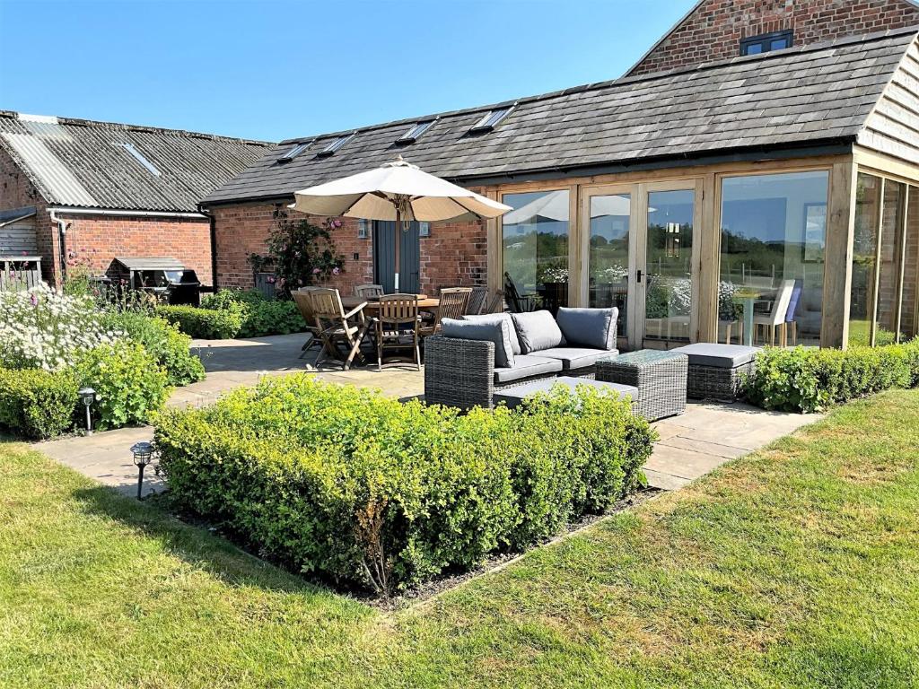 a patio with a couch and an umbrella at 5 bed in Llangollen 77696 in Whitchurch