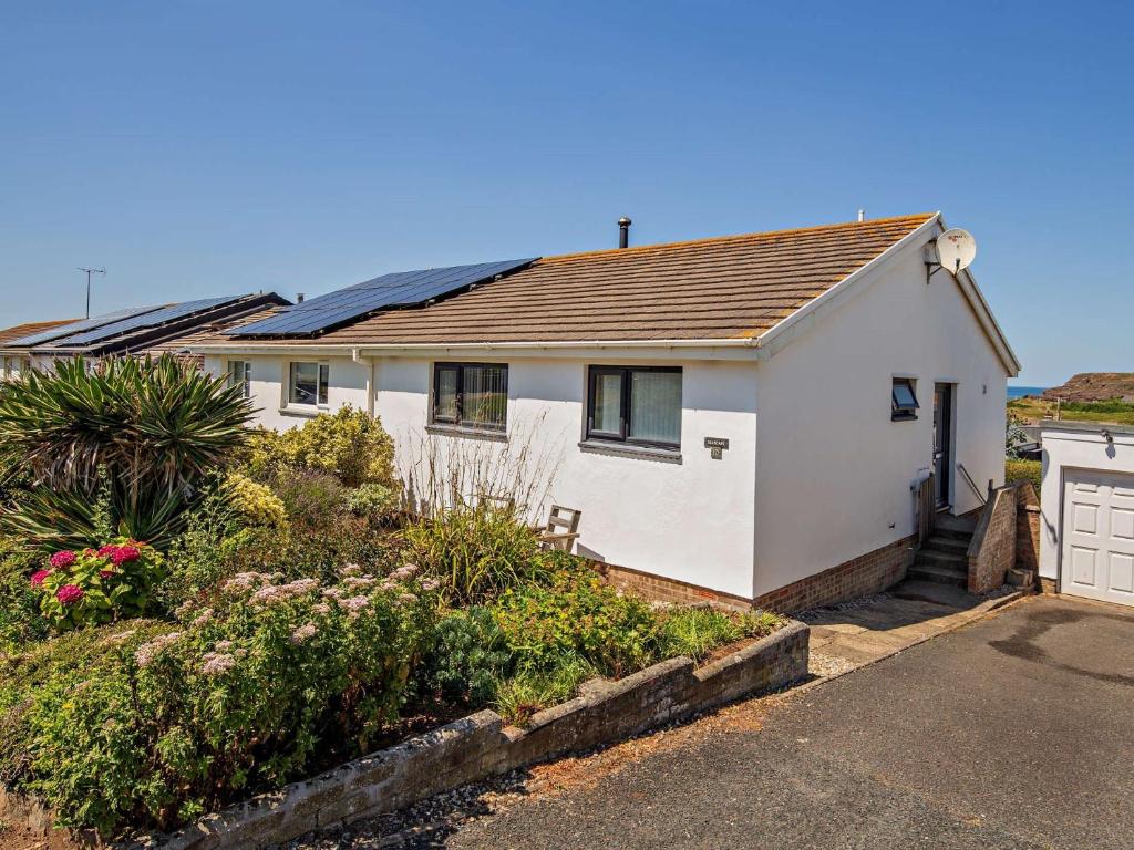 a white house with a roof and a driveway at 2 Bed in Widemouth Bay 40636 in Marhamchurch