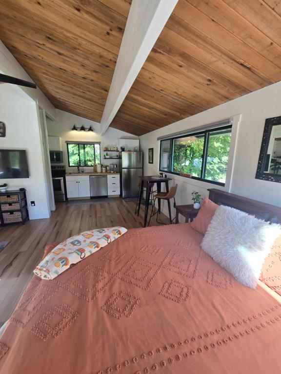 a bedroom with a large bed with a wooden ceiling at A Restful Studio Near a Creek and Forest - Pet Friendly in Roseburg