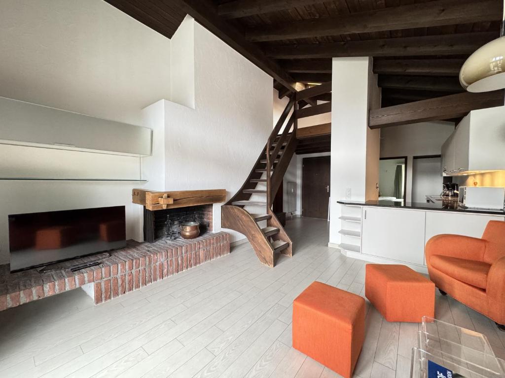 a living room with a fireplace and a staircase at Casa Laret 6-12 in Laax-Murschetg