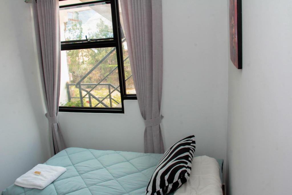 a bedroom with two windows and a bed in a room at Valle Sagrado Mágico in Urubamba