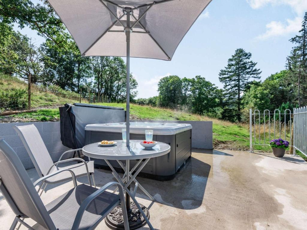 a table and chairs with an umbrella on a patio at 1 bed in Machynlleth 85207 in Darowen
